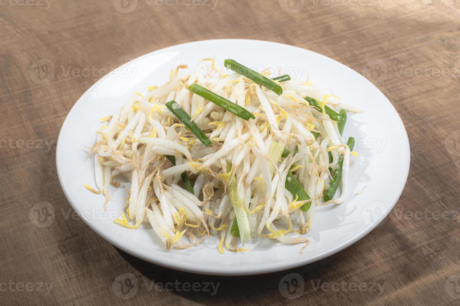 Healthy vegetarian food fried bean sprout in plate on wood table. photo