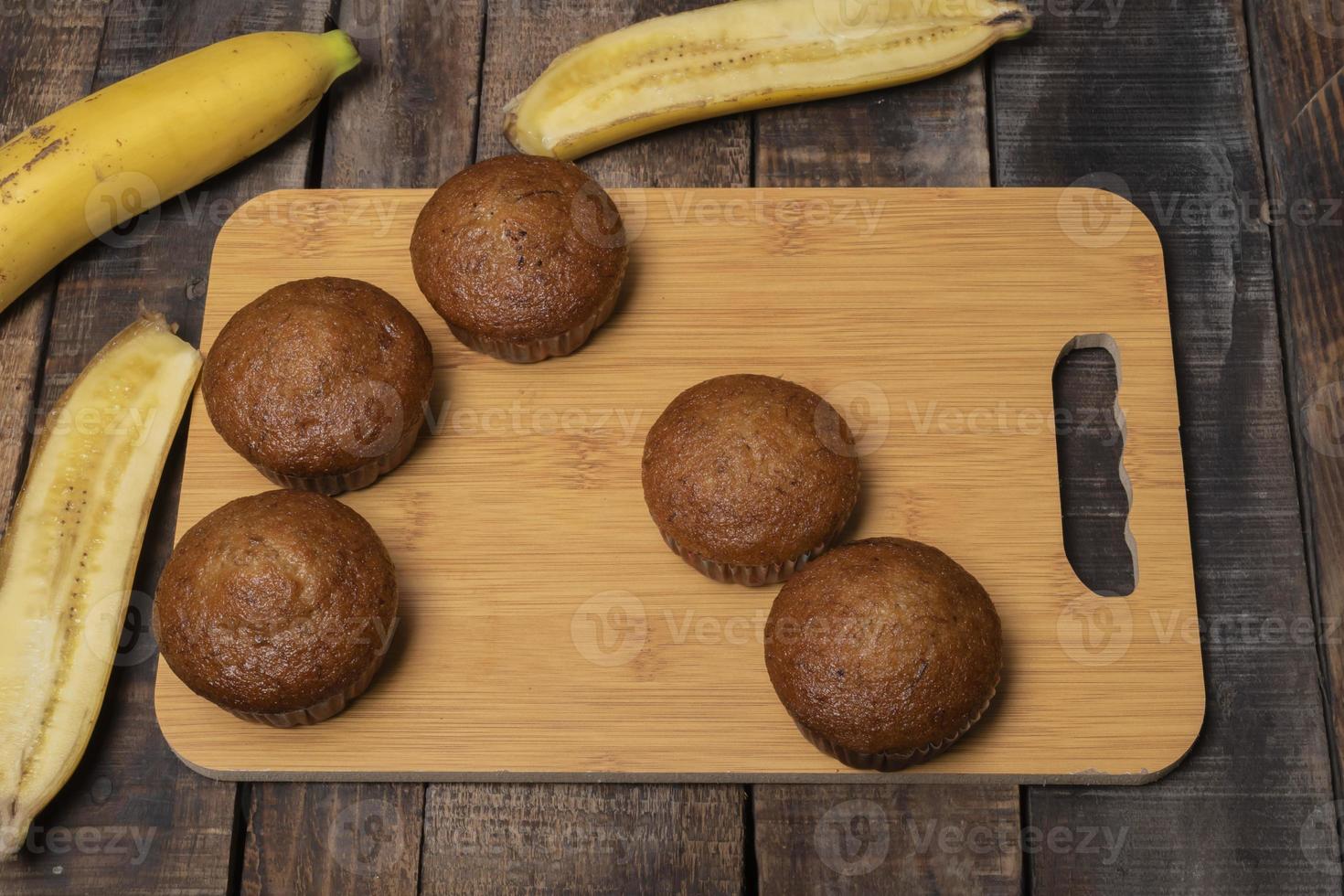 Banana muffins cake in cutting board on wood table. photo