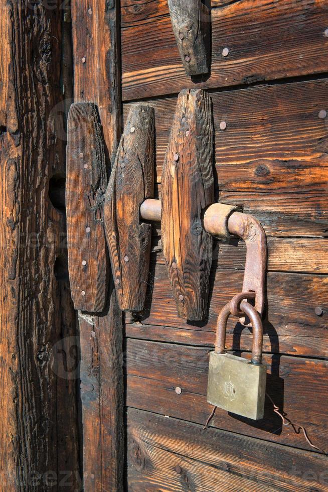 Padlock on antique wooden door photo