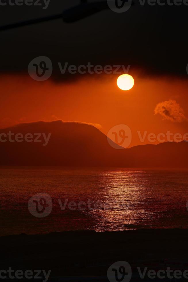 sol ardiente al atardecer sobre el océano pacífico en perú foto
