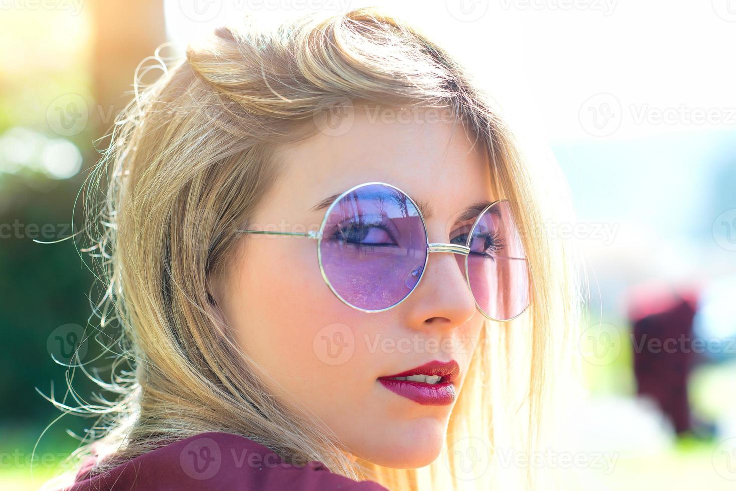 retrato de una hermosa chica rubia con anteojos morados transparentes foto