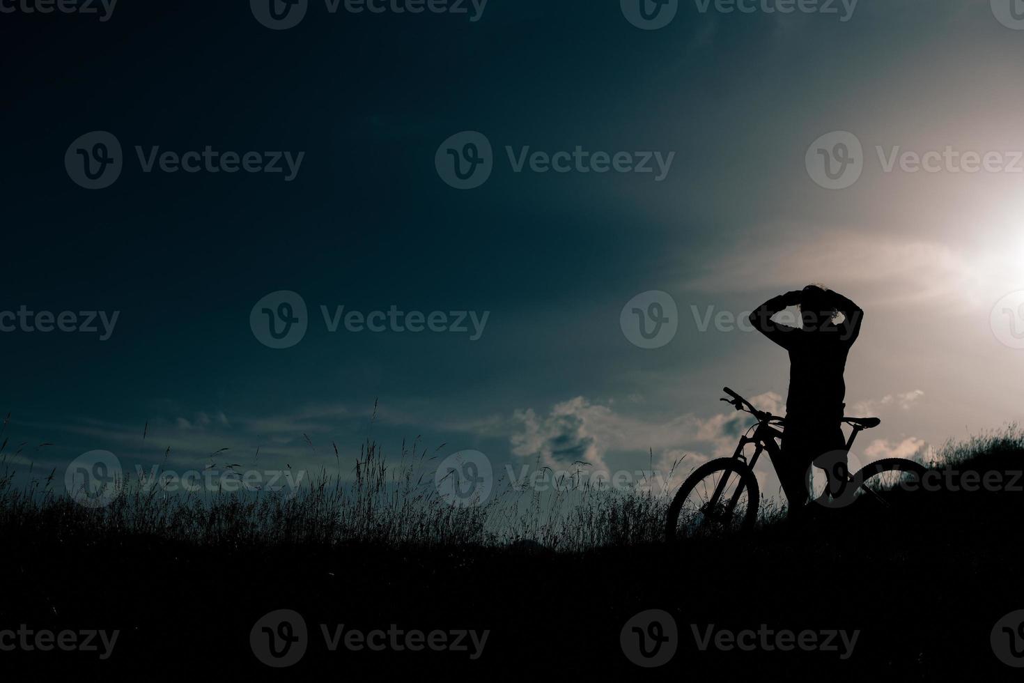 Cyclist with ebike rests and looks the landscape photo