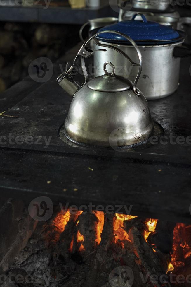 Stainless steel kettle on a wood stove. photo