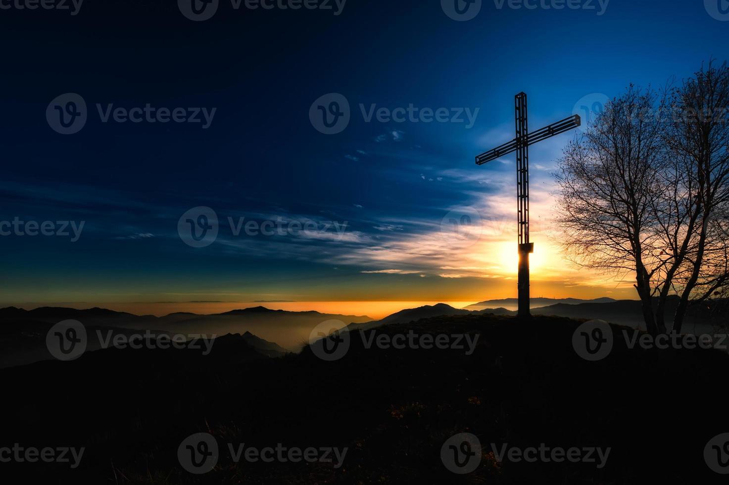 Summit cross a mountain at sunset photo