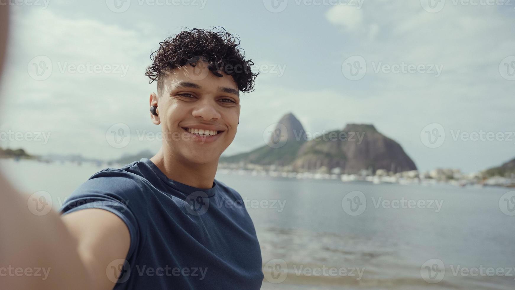 Latin young man, famous beach Rio de Janeiro, Brazil. Latin summer vacation holiday. photo