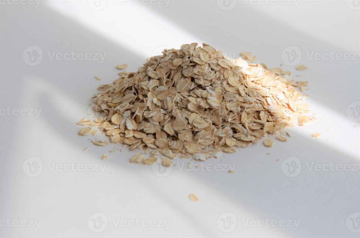 raw oatmeal on a white background, minimalism photo