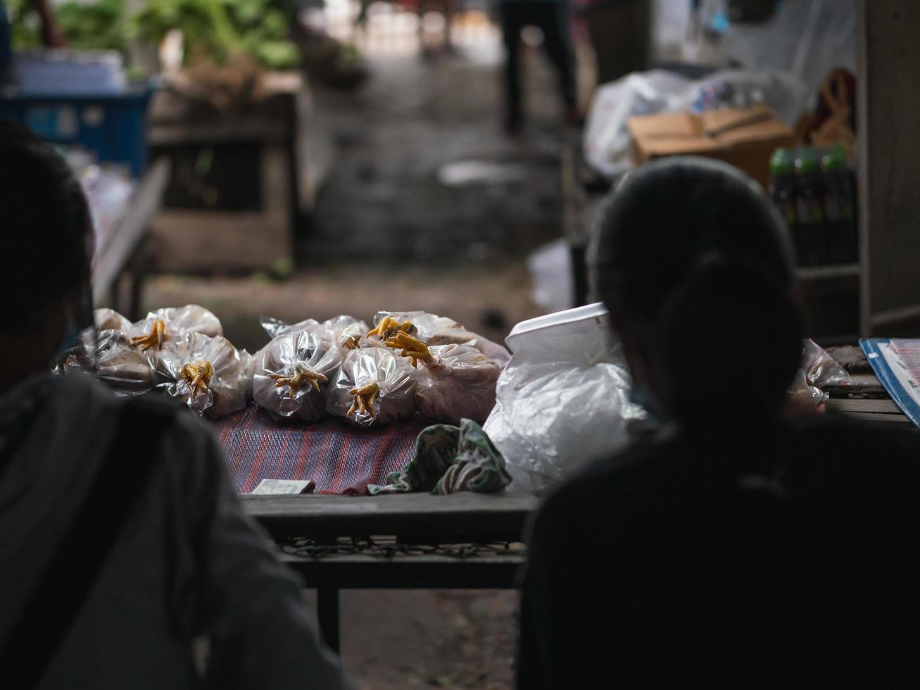 Chiang Mai Province, Thailand 2021 - Seller waiting for the customer at the fresh chicken stall in the Saturday flea market. photo