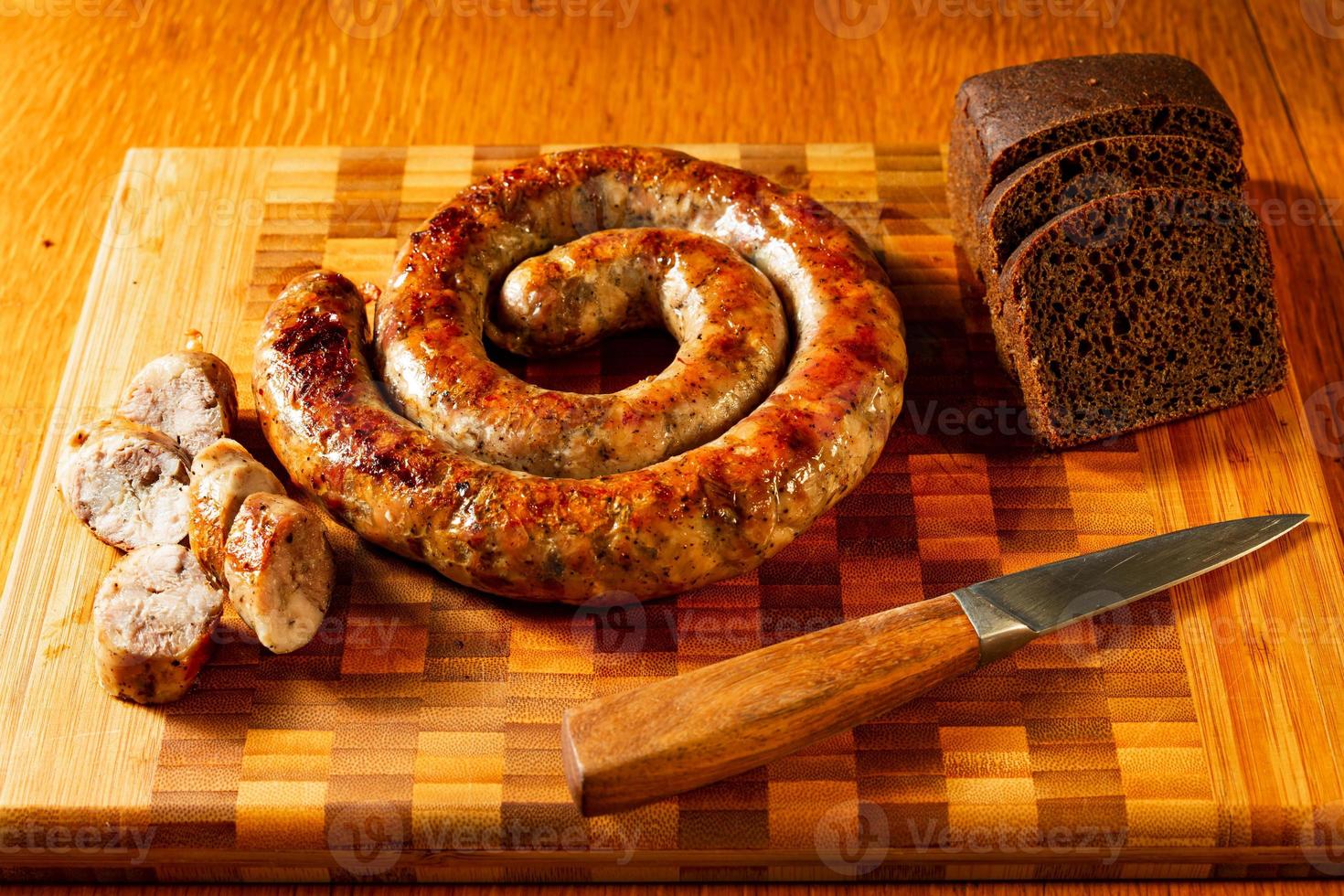 salchichas a la parrilla en una tabla de cortar con pan foto