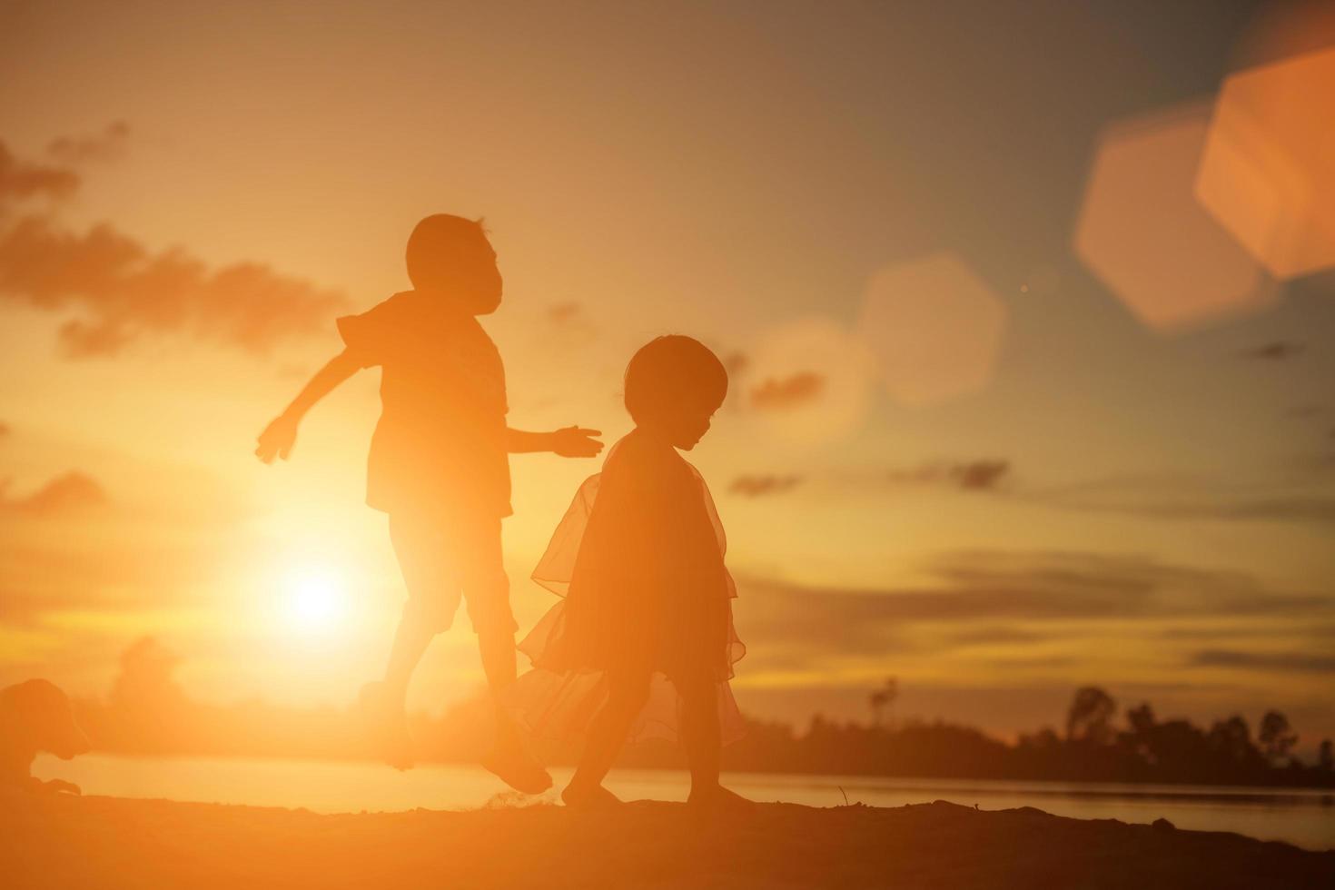 siluetas de madre e hija caminando al atardecer foto