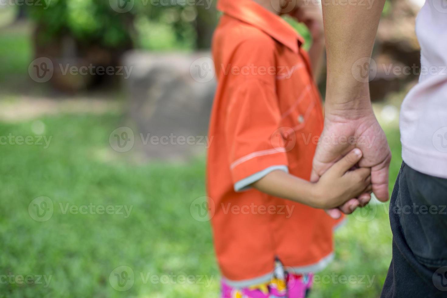 a the parent holds the hand of a small child photo