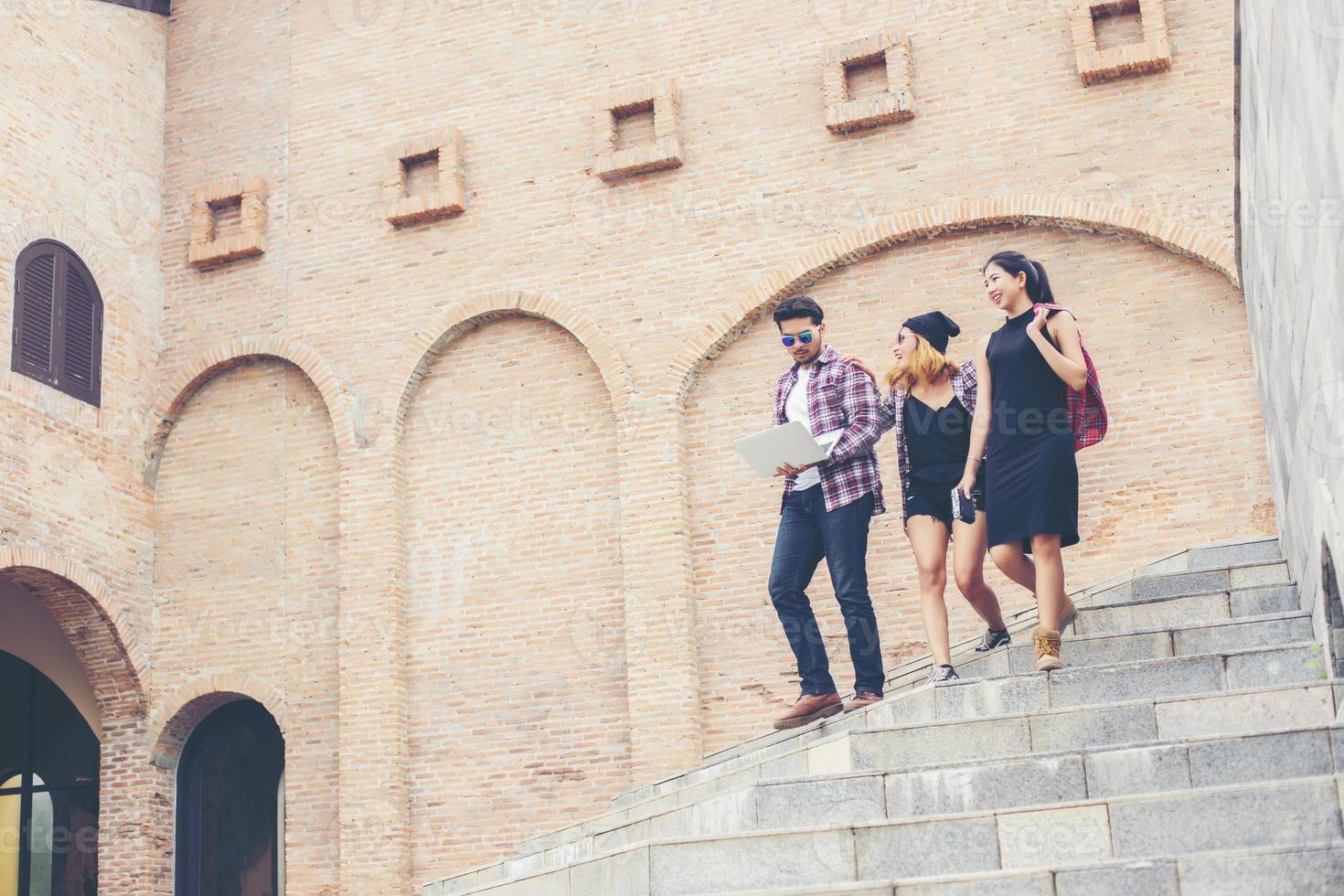 Summer holidays and hipster teenagers group traveling together in urban town having fun and happy time together. photo