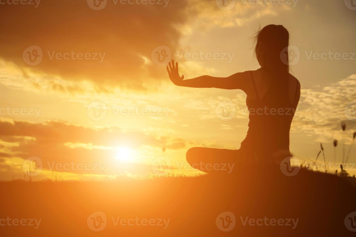 Silhouette of woman praying over beautiful sky background photo