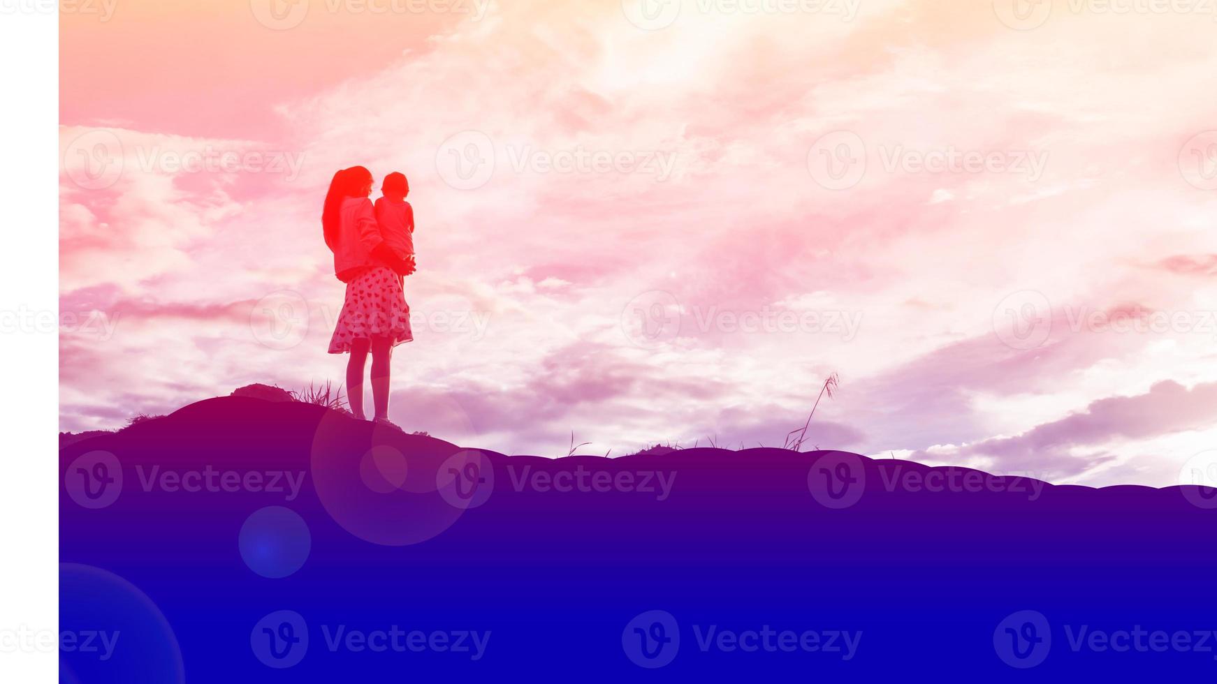 Mother encouraged her daughter out of the shadows at sunset. photo