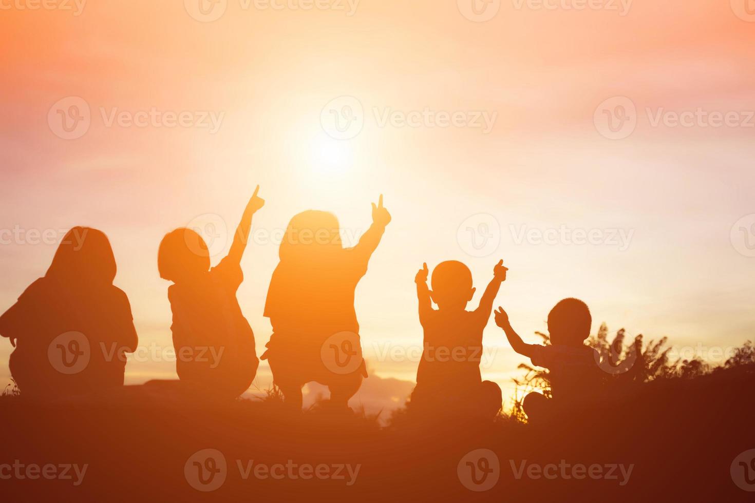 silueta de niños felices y puesta de sol feliz foto