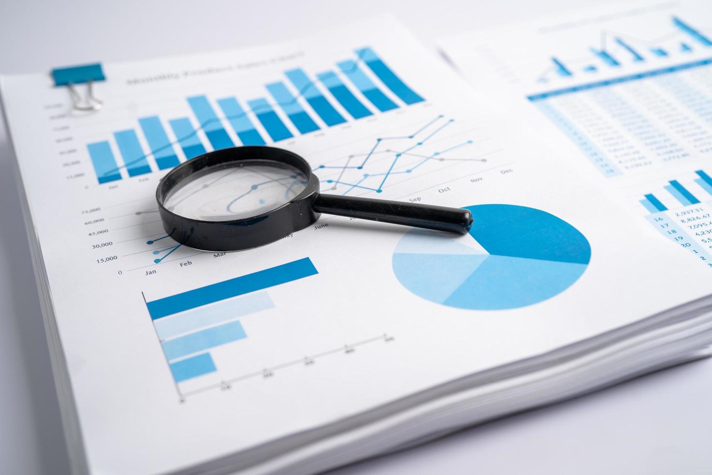 Magnifying glass on charts graphs paper. Financial development, Banking Account, Statistics, Investment Analytic research data economy, Stock exchange trading, Business office company meeting concept. photo