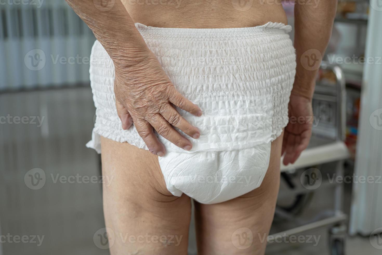 Paciente asiático mayor o mayor de la mujer de la señora mayor que lleva el pañal de la incontinencia en la sala del hospital de enfermería, concepto médico fuerte sano. foto