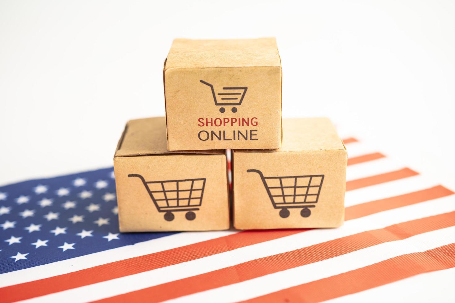 Box with shopping online cart logo and USA America flag, Import Export Shopping online or commerce finance delivery service store product shipping, trade, supplier concept. photo