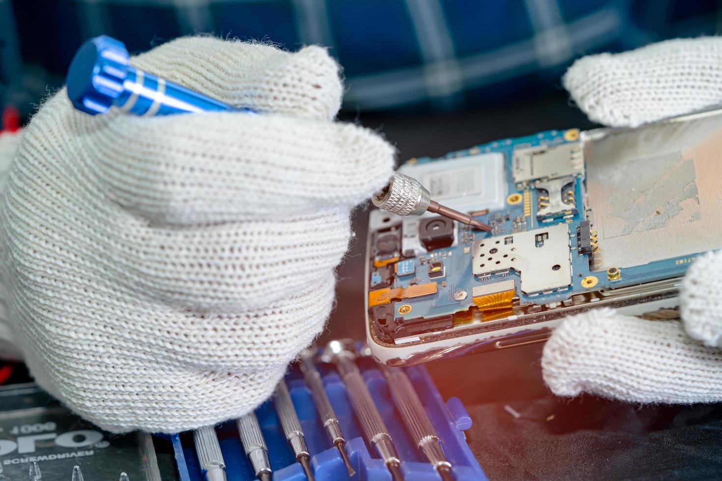 Technician repairing inside of mobile phone by soldering iron. Integrated Circuit. the concept of data, hardware, technology. photo