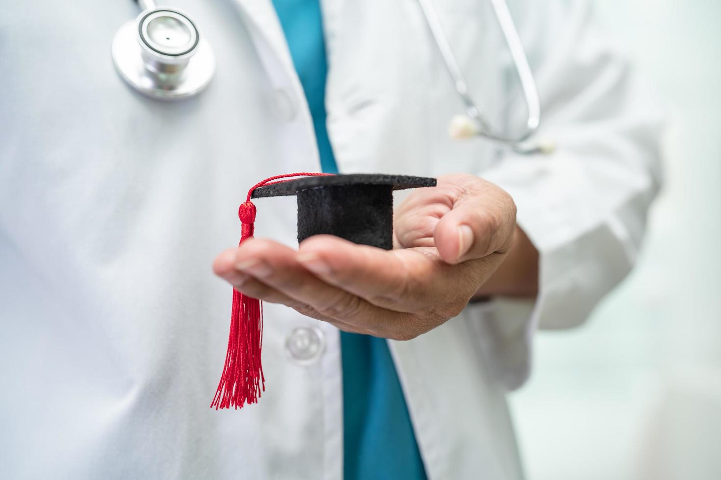 el estudio de un médico asiático aprende con un sombrero de brecha de graduación en la sala del hospital, un concepto de medicina inteligente y brillante. foto