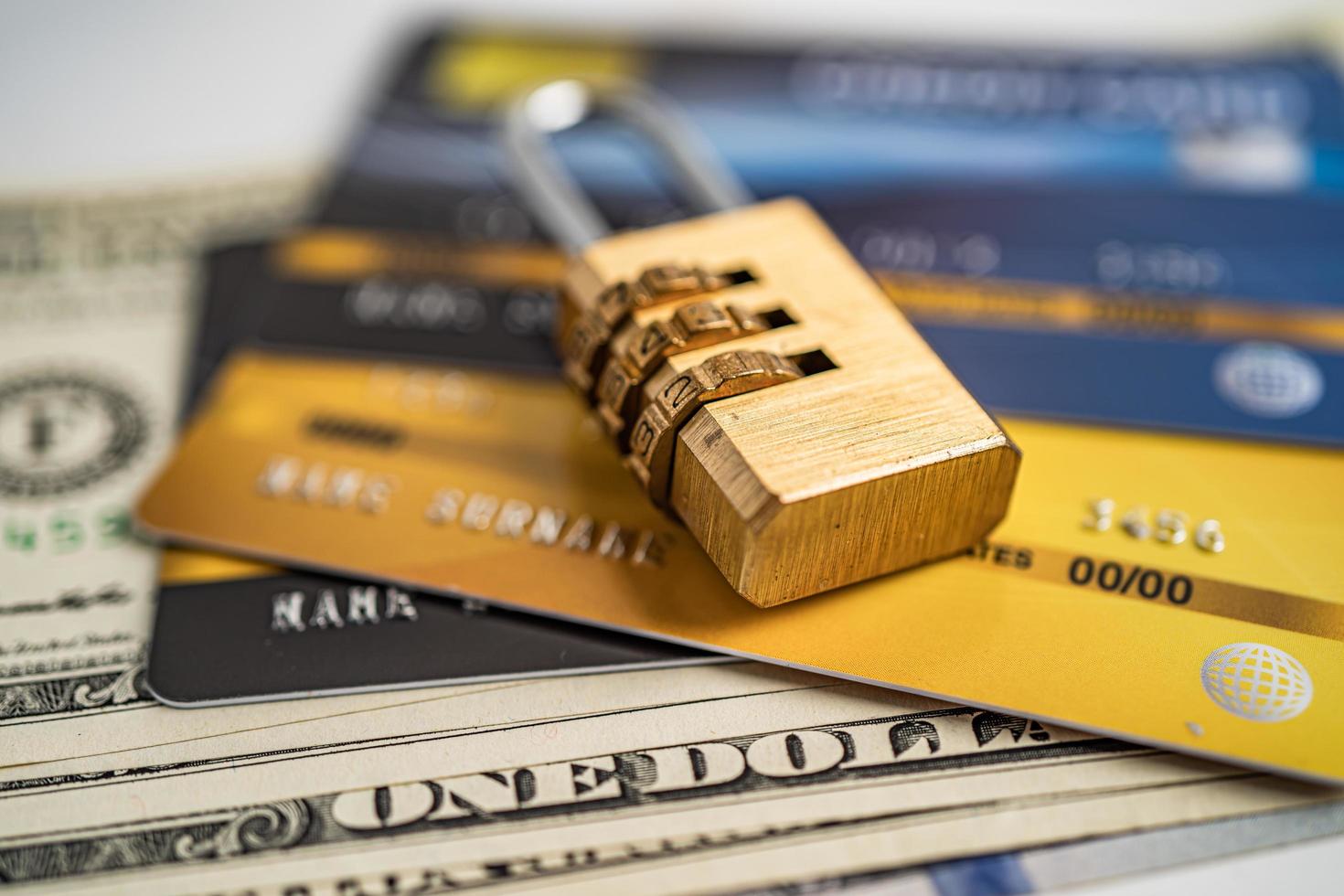 tarjeta de crédito con bloqueo de clave de contraseña en el fondo del dólar estadounidense. foto