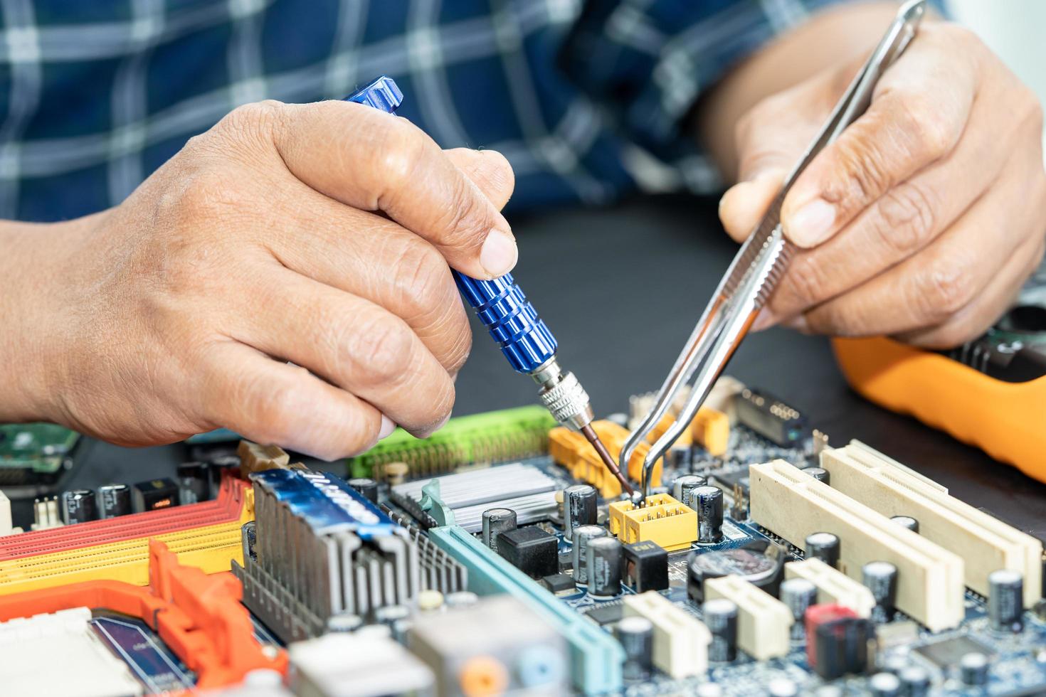 Technician repairing inside of mobile phone by soldering iron. Integrated Circuit. the concept of data, hardware, technology. photo