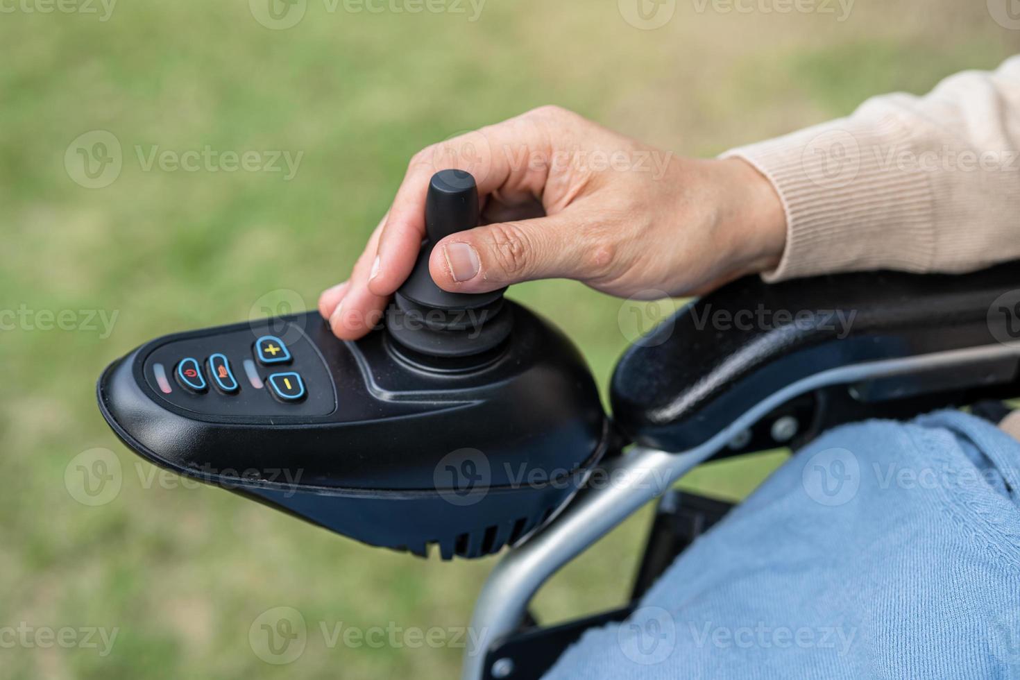 Asian lady woman patient on electric wheelchair with joystick and remote control at nursing hospital ward, healthy strong medical concept photo