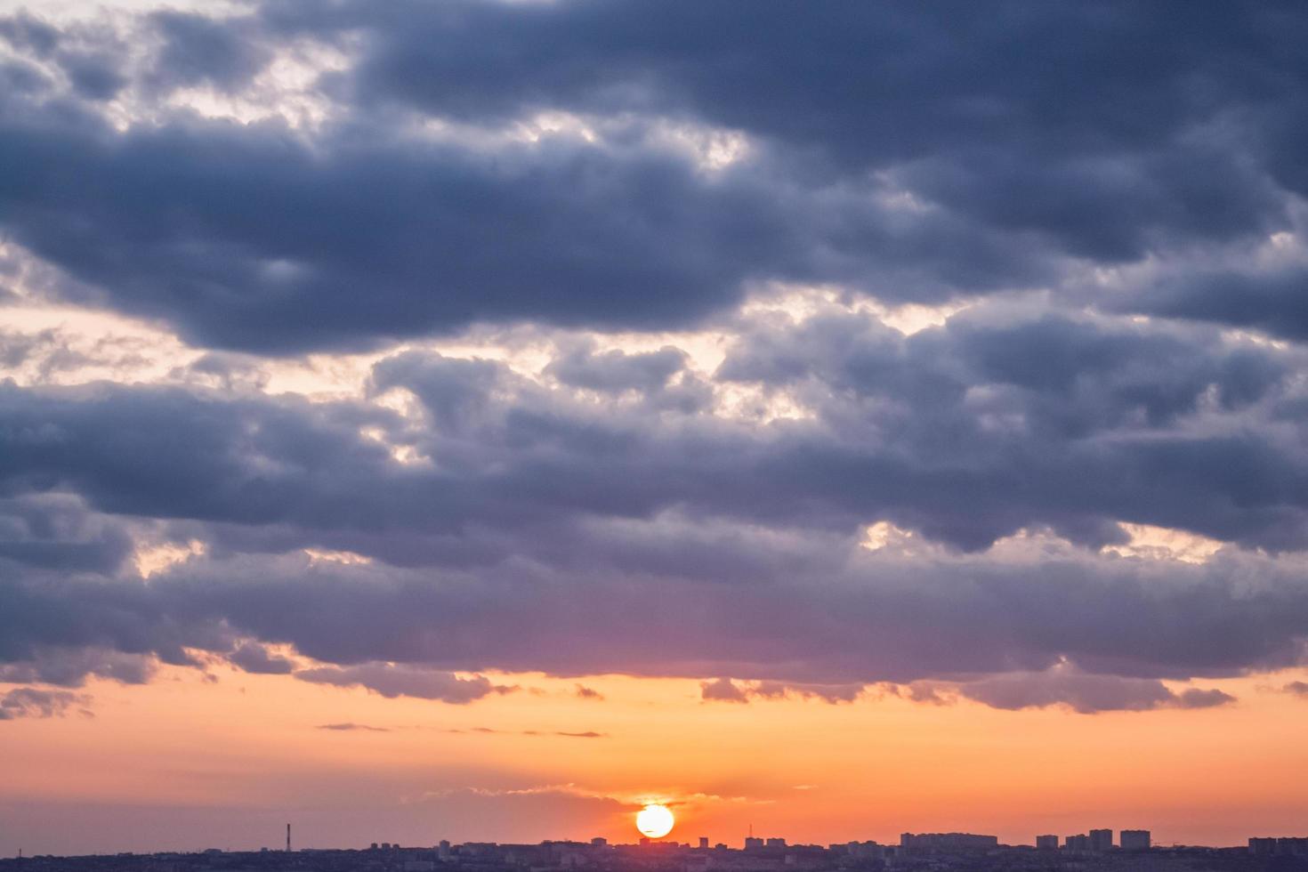 Colorful cloudy sunset landscape with city buildings on the horizon. photo