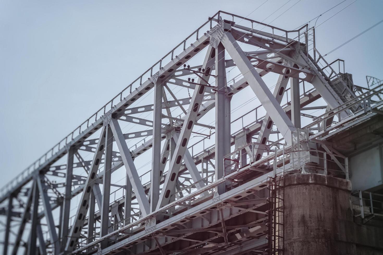 Railway bridge made of metal beams on a concrete base. photo