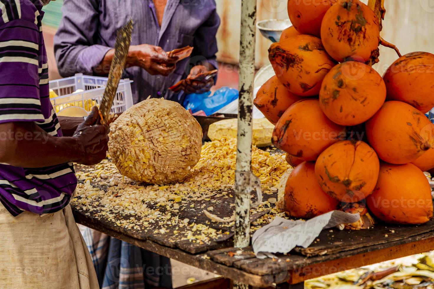 preparación de un coco para beber en un mercado de colombo en sri lanka foto