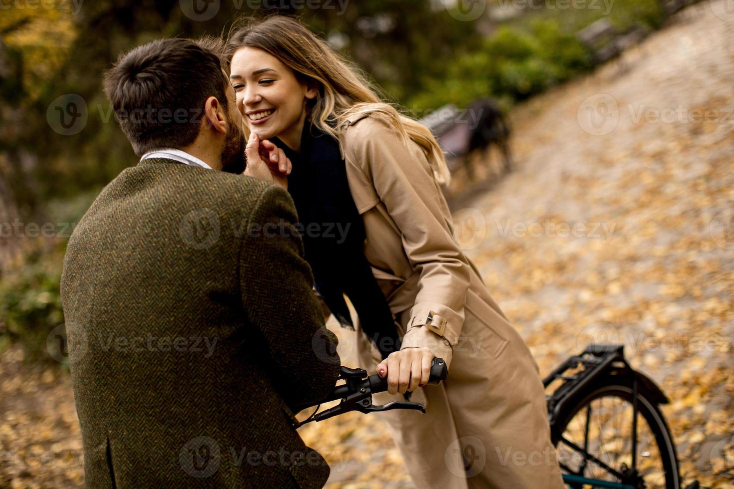 Young couple in the autumn park with electrical bicycle photo