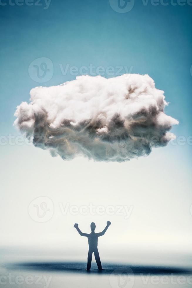 Angry man with clenched fists standing under a cloud. photo