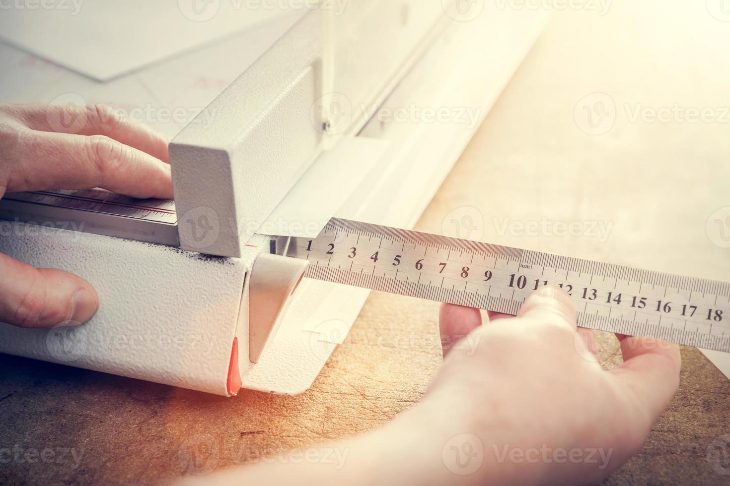 Man does measuring with slide calliper in paper cutter photo