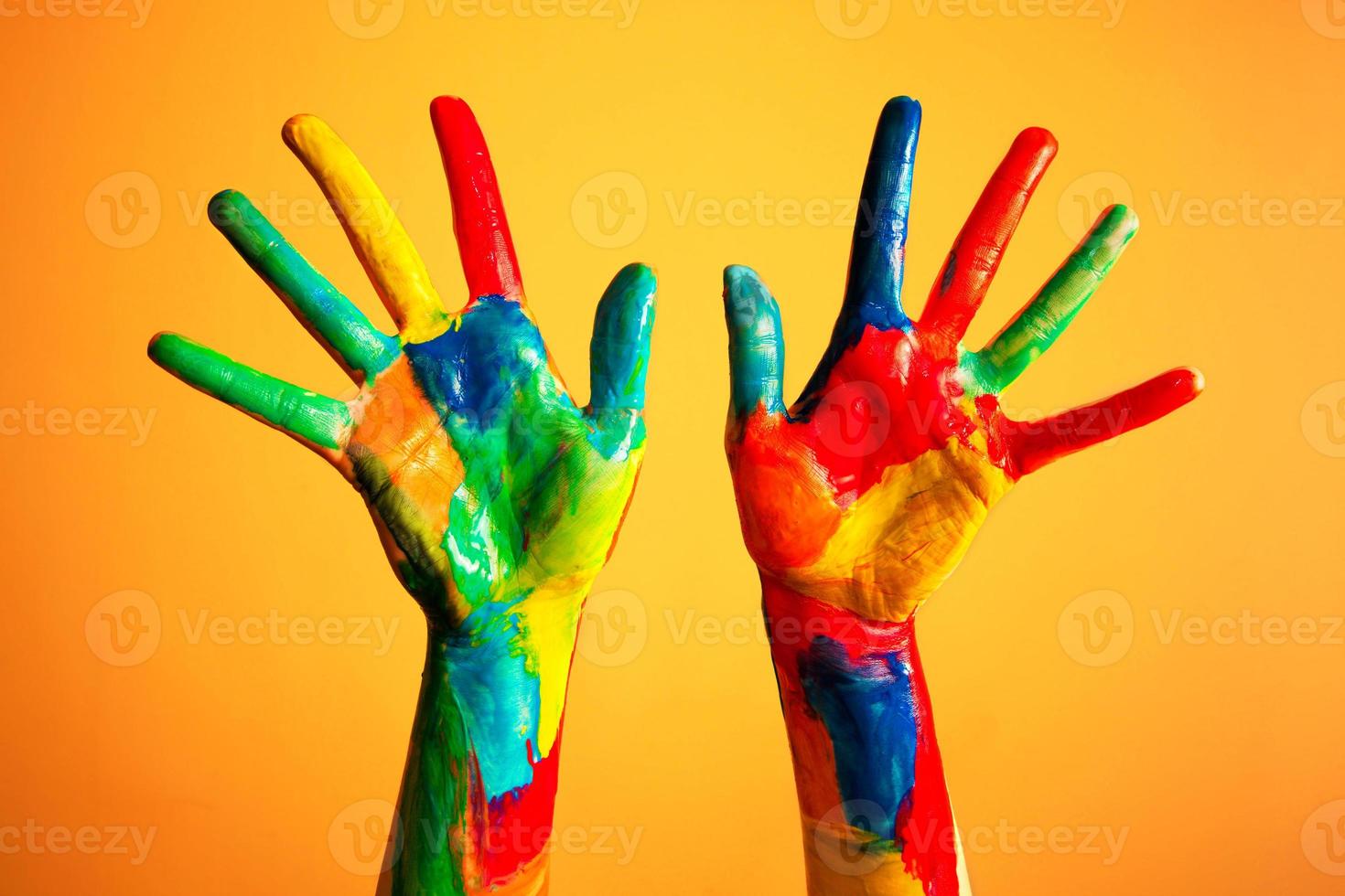 Painted hands, colorful fun. Orange background photo