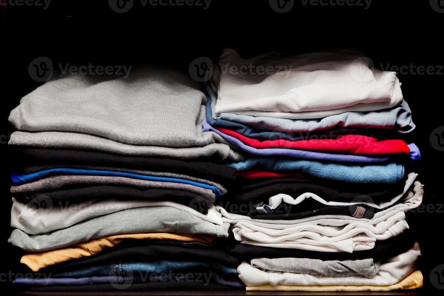 PIles of various clothes from laundry in a wardrobe photo