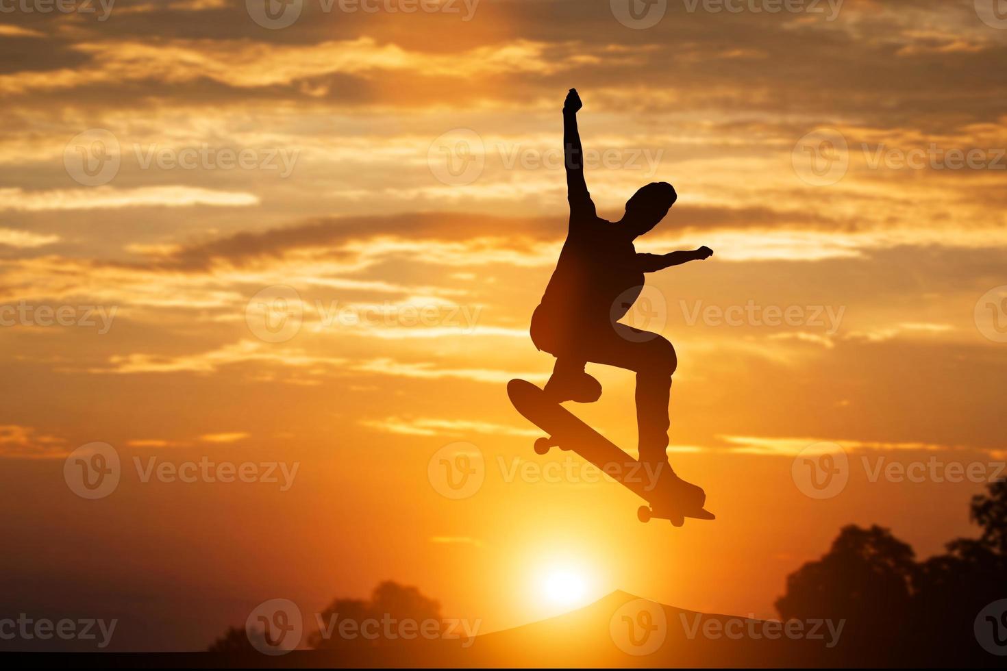 Skateboarder jumping at sunset. photo