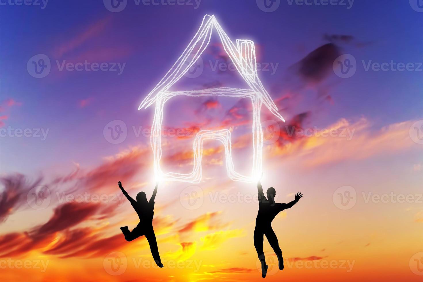 A couple jump and make a house symbol of light. New home, mortgage. photo