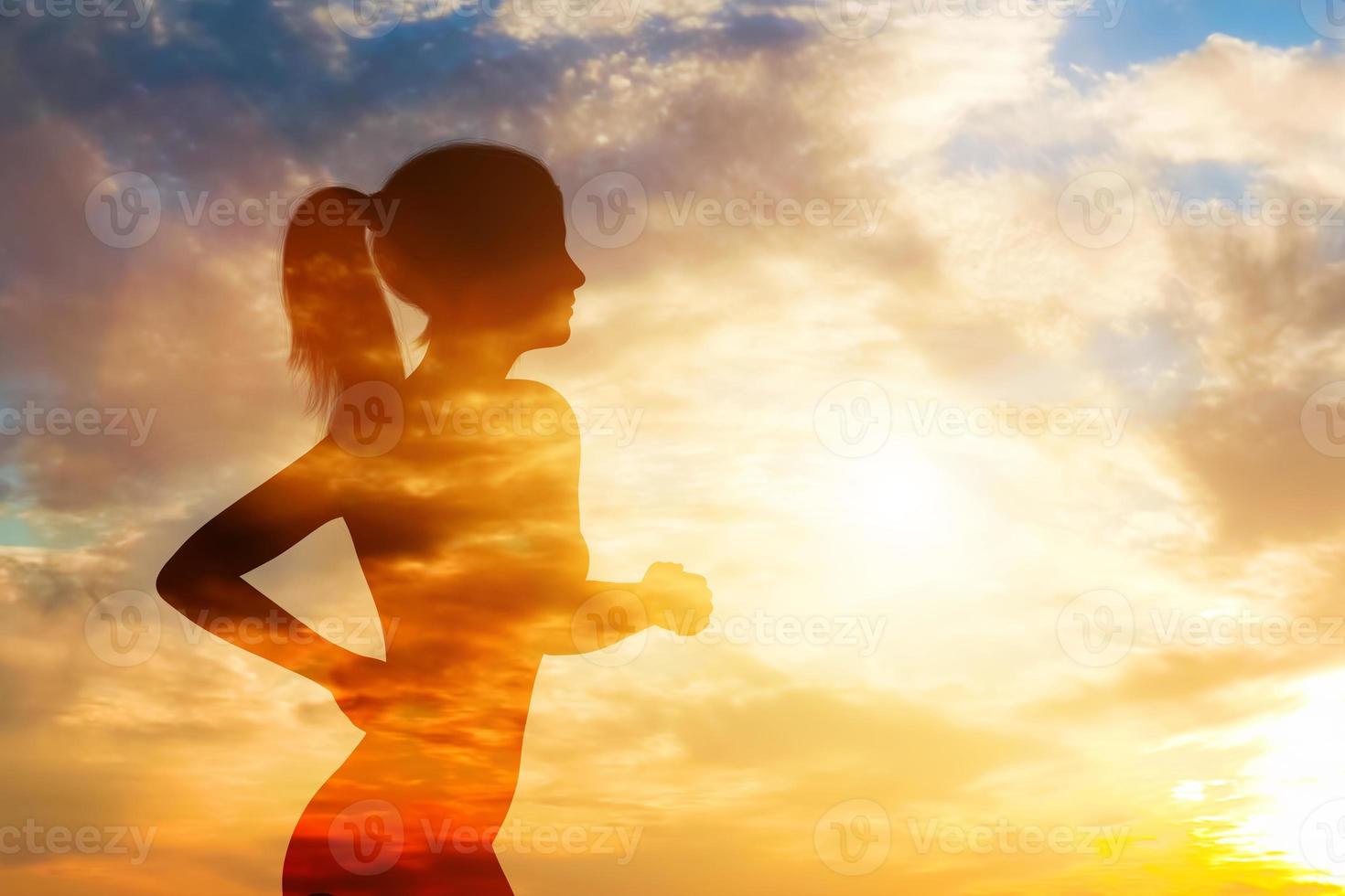 Silhouette of a running woman on sky background. photo