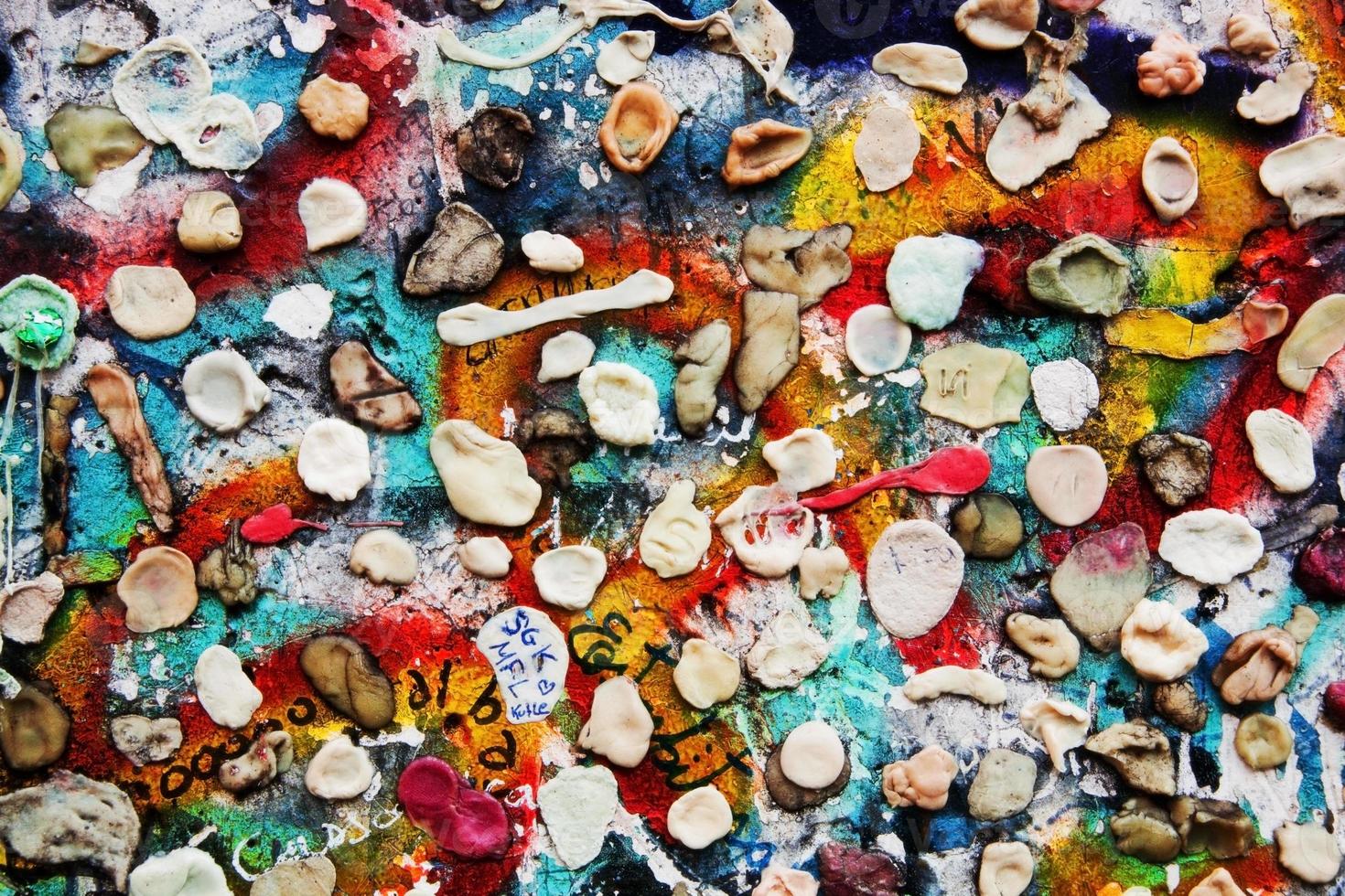 Part of Berlin Wall with graffiti and chewing gums photo