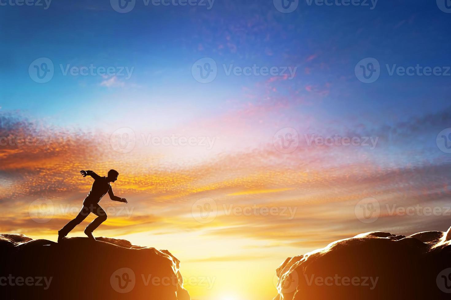 hombre corriendo rápido para saltar sobre el precipicio entre dos montañas. desafío foto