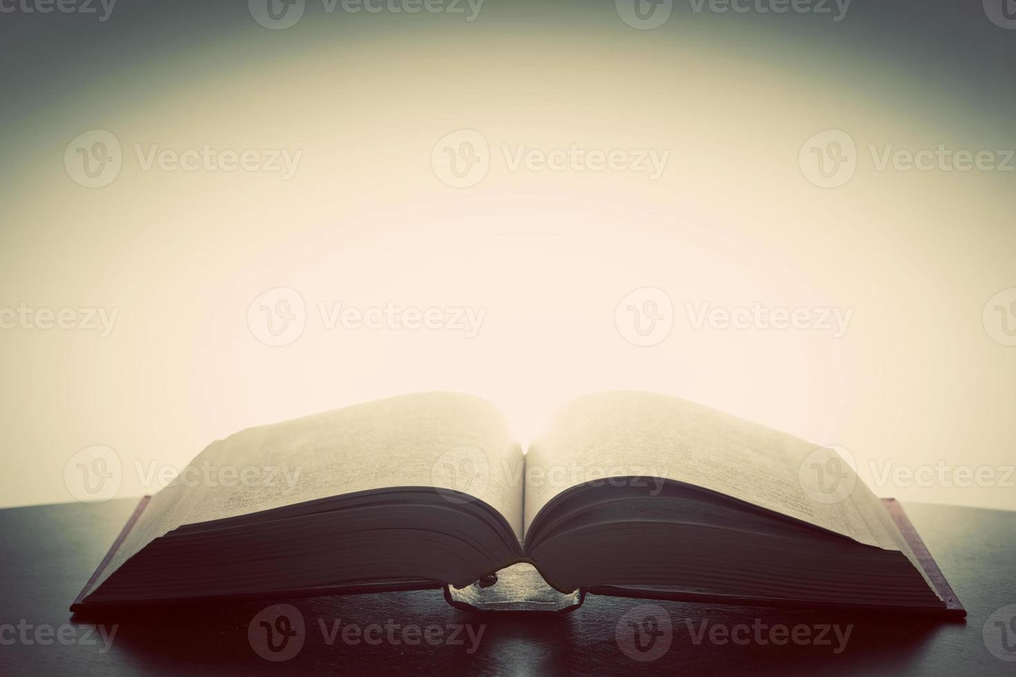 Open old book, light from above. Fantasy, imagination, education photo