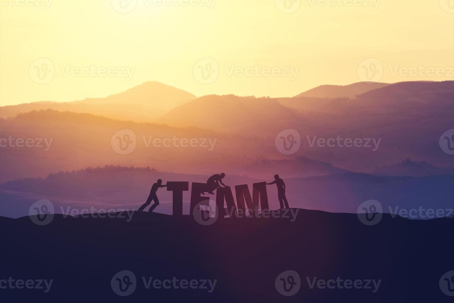 Three people creating TEAM writing on a field. photo