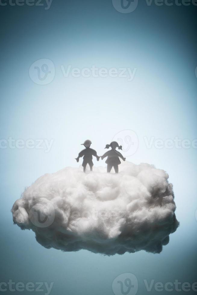 Two children standing on a white cloud. photo