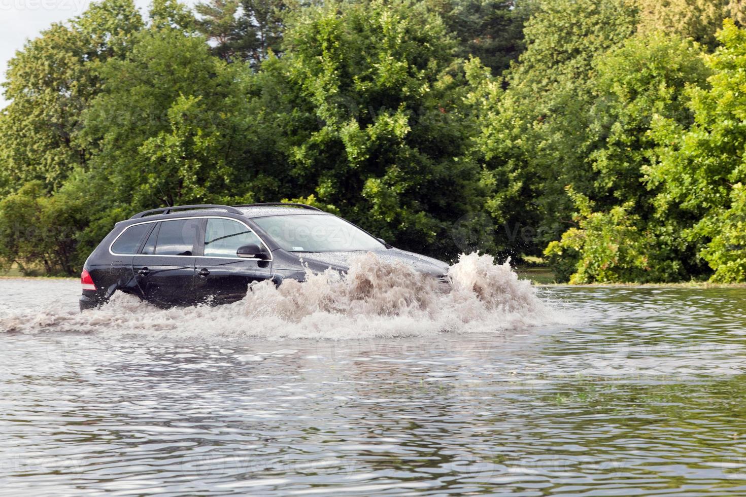 Car trying to drive against flood on the street in Gdansk, Poland. photo