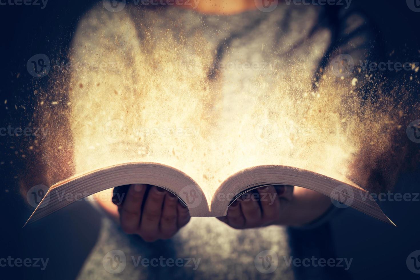 mujer sosteniendo un libro abierto lleno de luz. foto