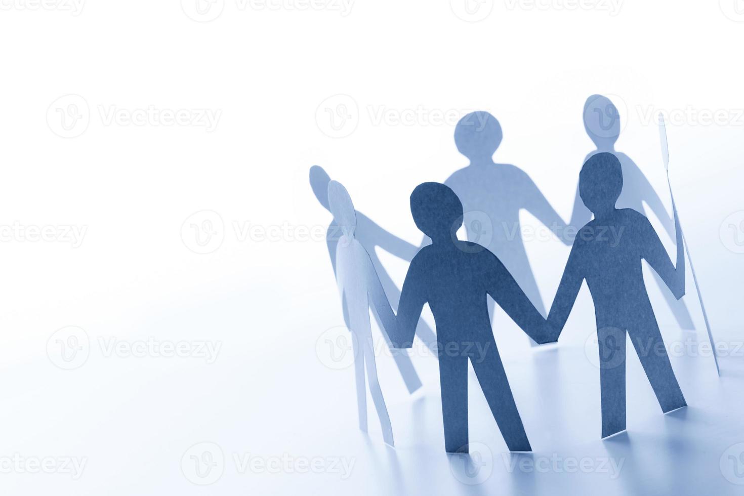 Paper people standing together hand in hand. Team, glabal business connection concept photo