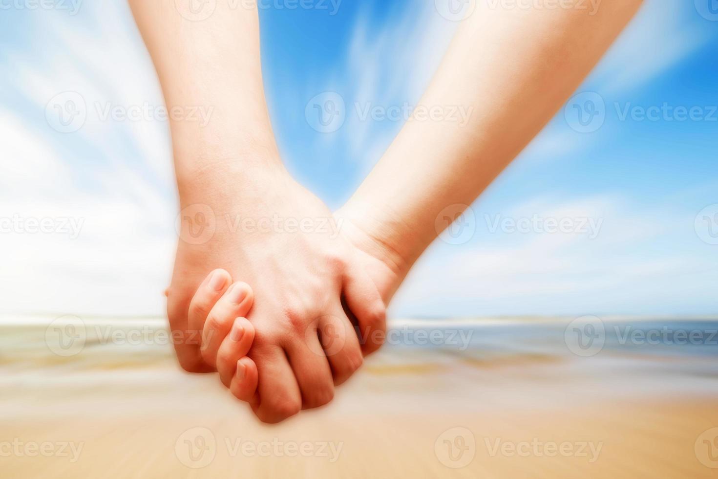 A couple in love hand in hand on the sunny beach photo