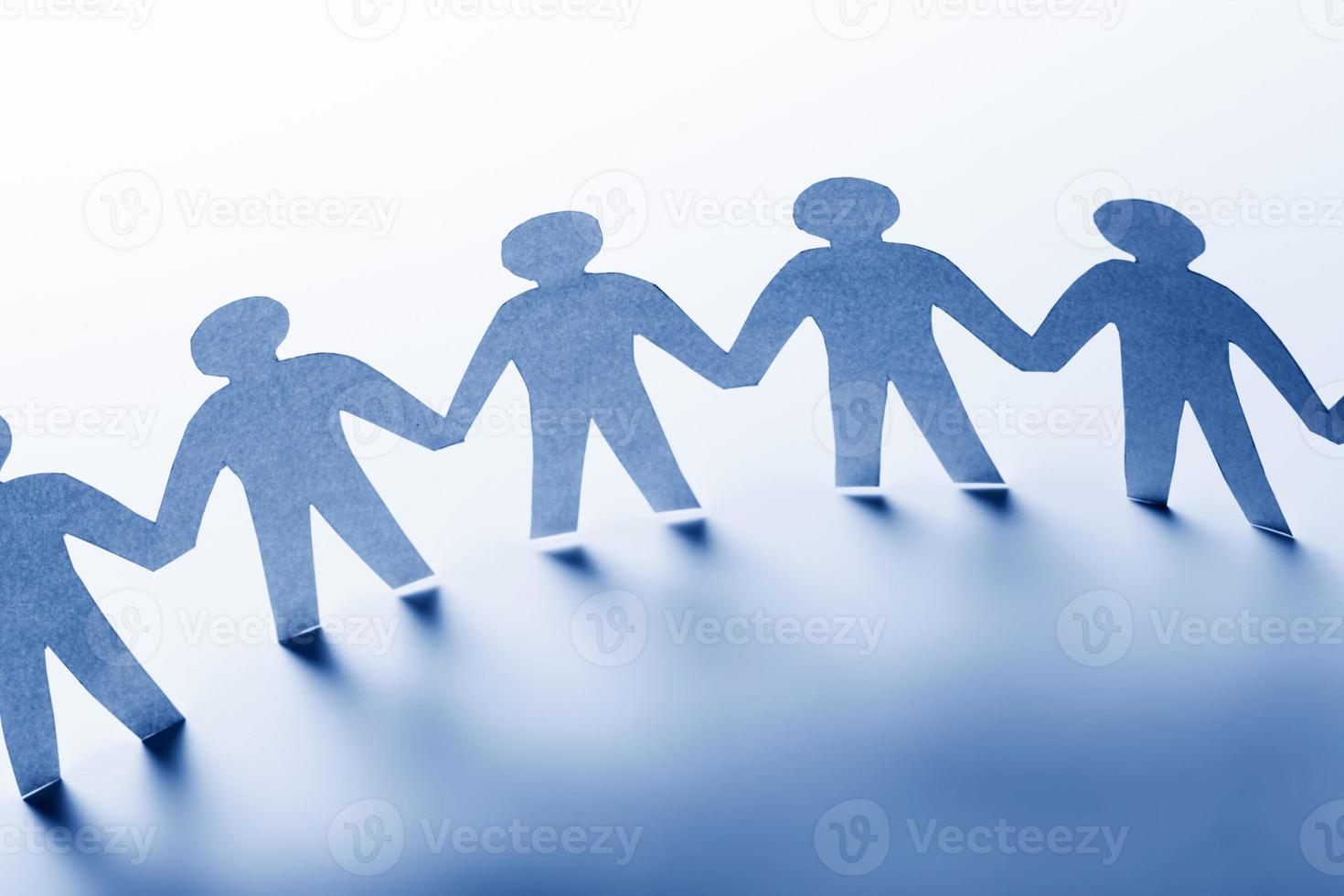 Paper people standing together hand in hand. Team, society, business concept photo