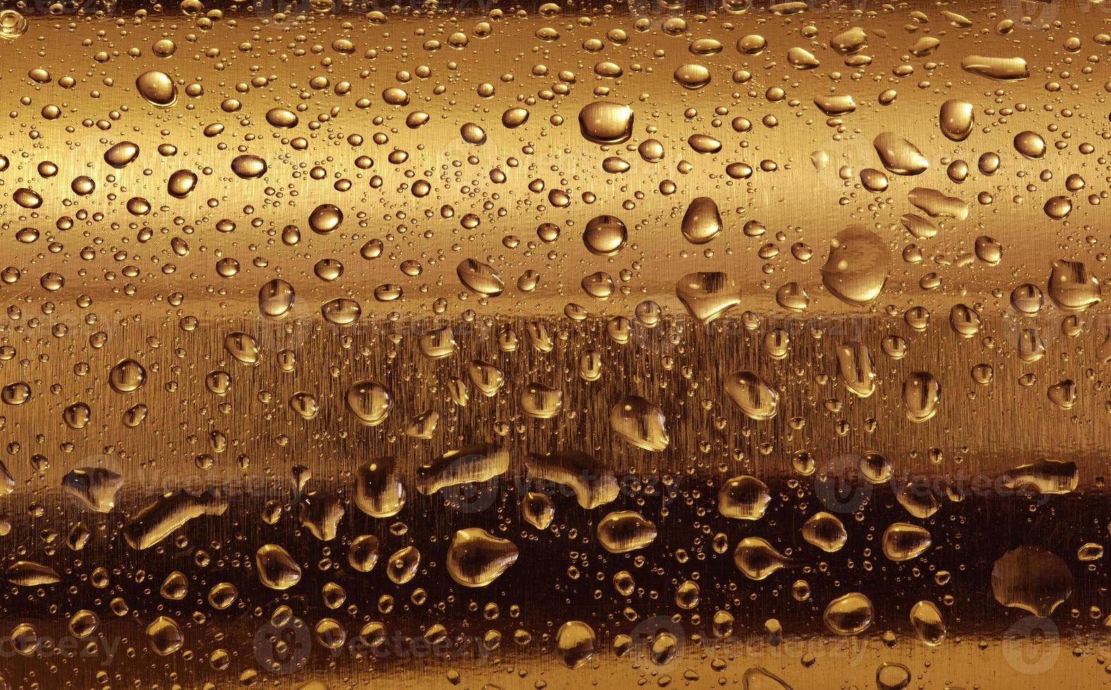 Gold plate with water drops on the rounded surface. photo