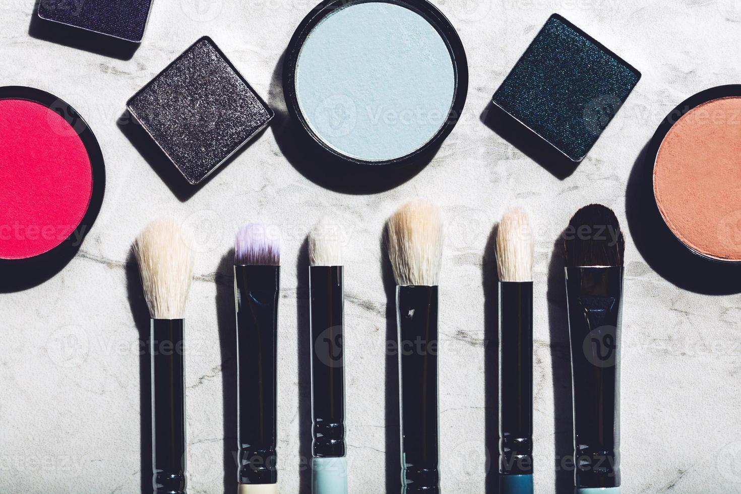 Makeup brushes and eyeshadows on a marble background photo