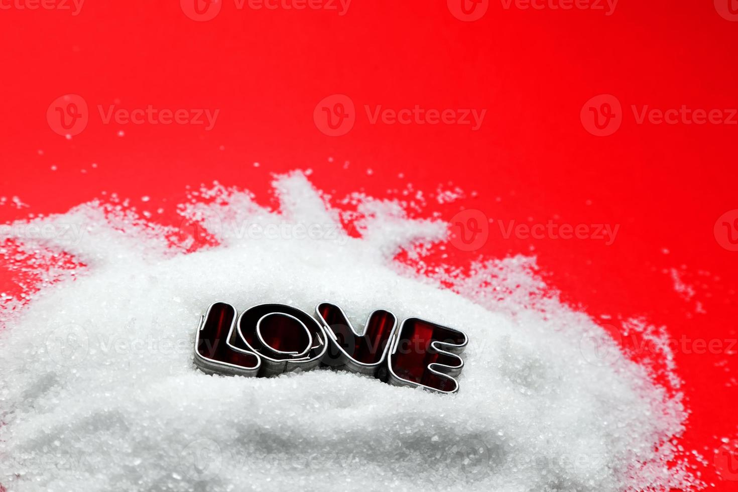 mensaje de texto de amor de letras en forma de galleta sobre azúcar y fondo rojo foto